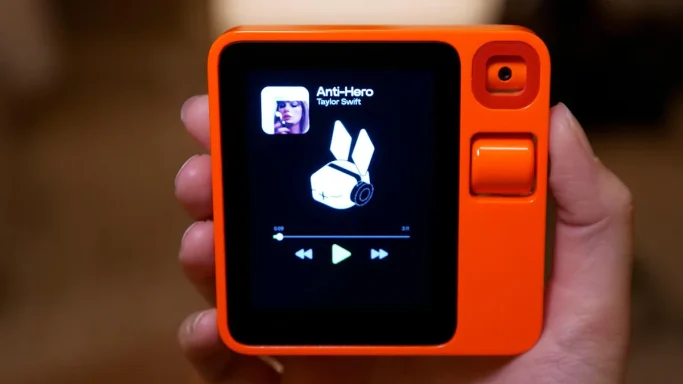 Orange handheld music player displaying a song title and album artwork.